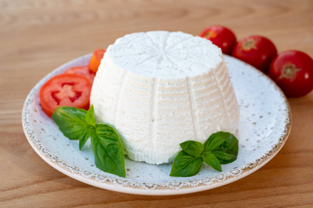 istock Cheese collection, white Italian soft cheese ricotta served with fresh tomatoes and basil 1345008441