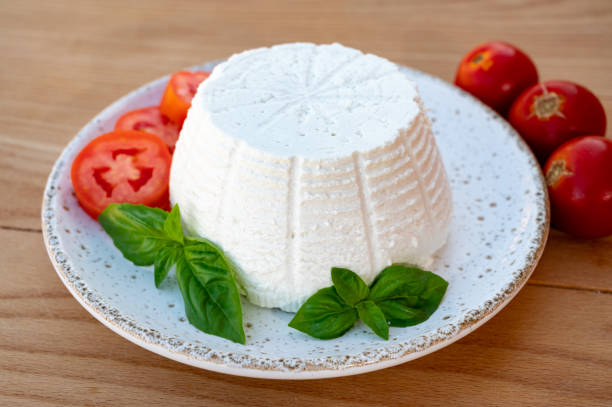 istock Cheese collection, white Italian soft cheese ricotta served with fresh tomatoes and basil 1345008445