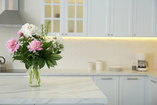 istock Peony bouquet on white marble table in kitchen interior 1345008710