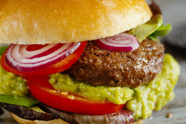 istock Burger with meat and avocado sauce served on wooden table. 1345009286