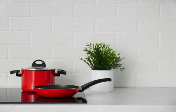 istock Saucepot and frying pan on induction stove in kitchen 1345009290
