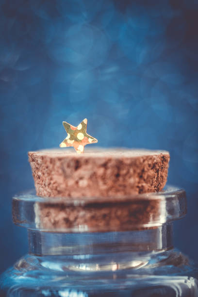 istock isolated shiny little star on a cork stopper. blue background. 1345009688