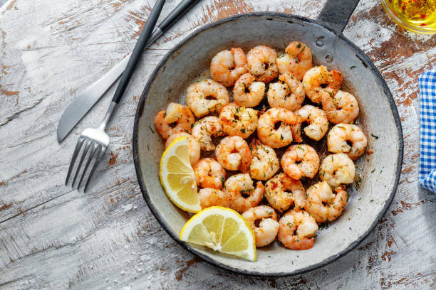 istock Tasty appetizing fried shrimps on pan on dark stone background. 1345009914