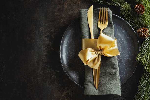 istock Served christmas table setting in dark tones with golden deco. 1345010030