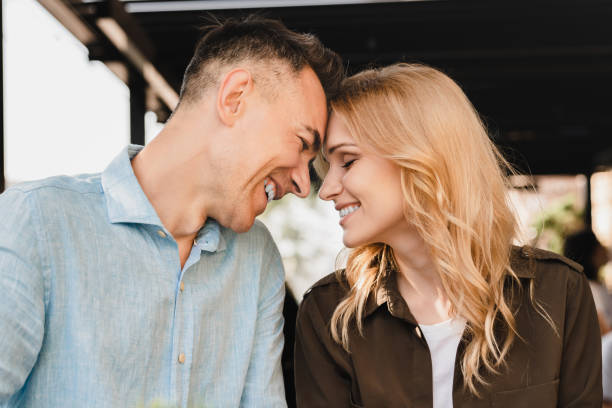 caucásico alegre romántico romántico pareja madura cónyuges marido y mujer abrazando abrazos mientras están en una cita juntos en un restaurante cafetería - heterosexual couple fotografías e imágenes de stock