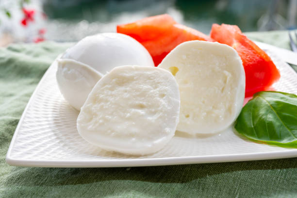 istock Cheese collection, fresh Italian soft cheese mozzarella di bufal campana served with fresh basil and tomatoes 1345012296