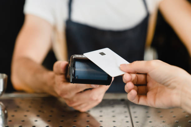 istock Cashless payment method. Closeup shot of micro ATMs while customer paying with credit card in bar restaurant cafe. E-commerce e-banking concept. 1345012499