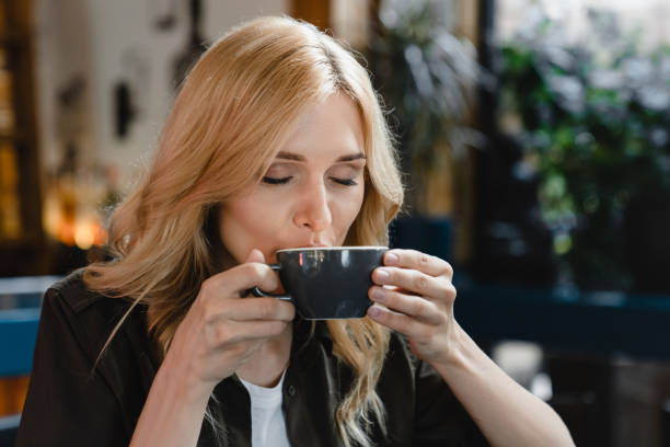 istock Caucasian young woman freelancer student drinking tea coffee hot beverage enjoying breakfast brunch in cafe restaurant in the morning 1345014659