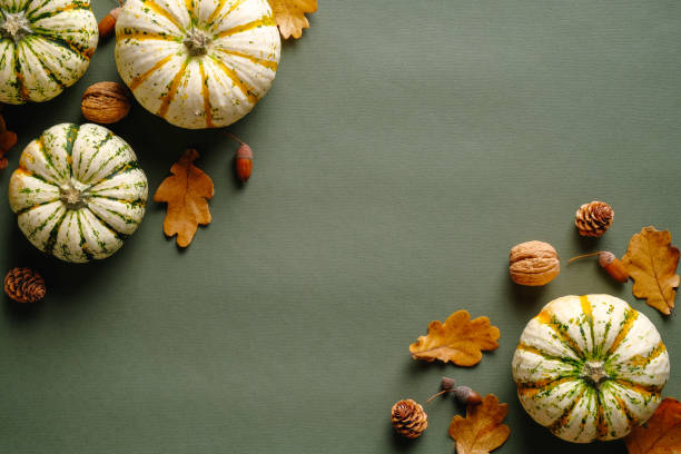 istock Happy Thanksgiving day concept. Autumn composition with ripe pumpkins, fallen leaves, walnuts, acorns on vintage green background. Flat lay, top view, copy space. 1345014971