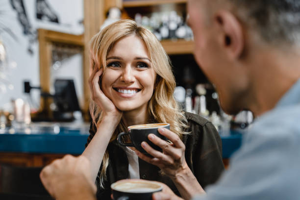 interesado emocionado enamorarse mujer madura escuchando a su marido hombre novio mientras toma café en el restaurante café en una cita - heterosexual couple fotografías e imágenes de stock