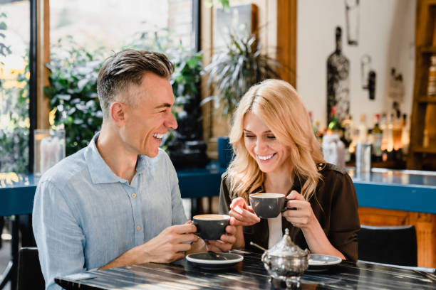 feliz y alegre pareja caucásica de mediana edad cónyuges bebiendo café hablando disfrutando de una cita romántica juntos en el bar cafetería restaurante - heterosexual couple fotografías e imágenes de stock