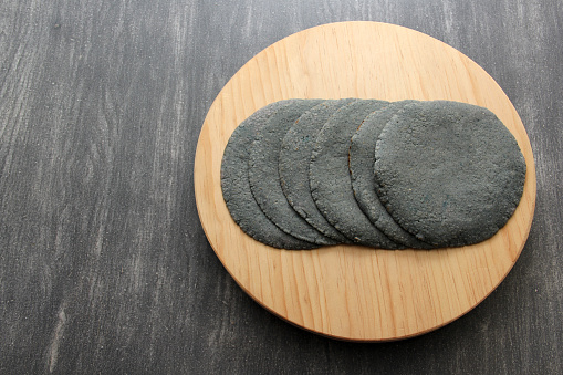 blue masa tortillas on a red napkin on wooden board ready to accompany Mexican food