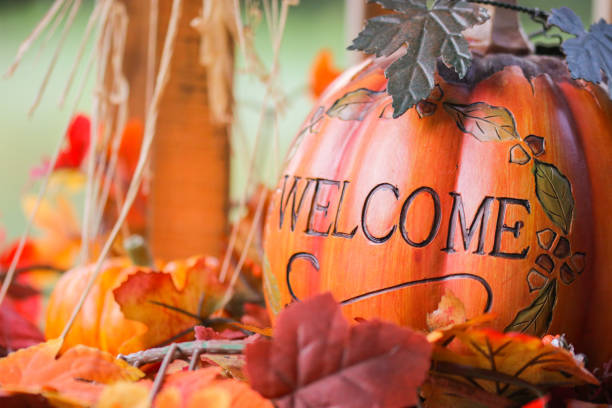 istock Welcome pumpkin and autumn colored leaves 1345019366