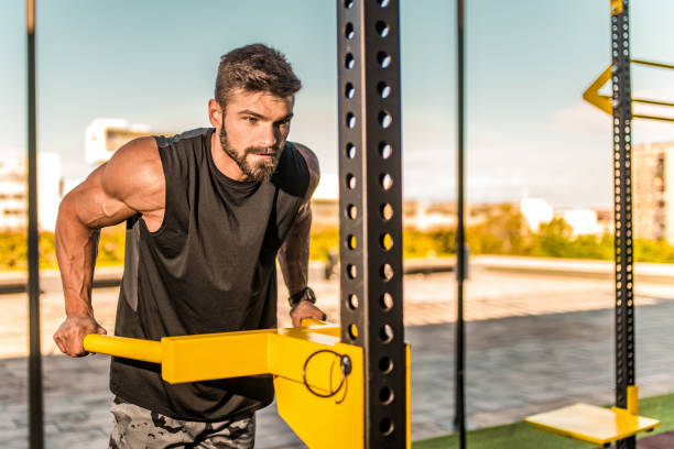 istock Young bodybuilder doing triceps workout at the outdoor gym. 1345019384