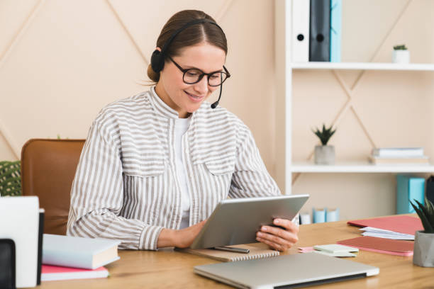 istock Teleworker online helper call center hotline worker interpreter assistant in headset using digital tablet for remote work, e-commerce, e-banking concept. 1345027772