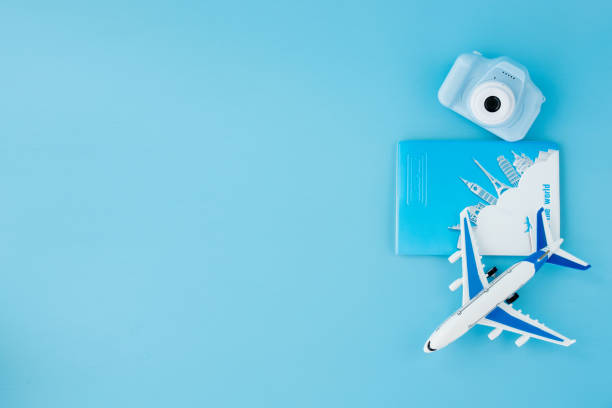 istock Camera, passport and airplane on light blue background.Summer or vacation concept. Copy space. 1345028514