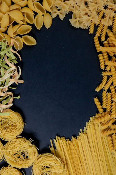 istock Assortment of different types of pasta dry on black background. 1345028521