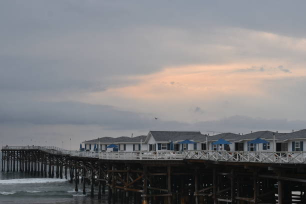 istock Cloudy Beachscape with Pier and Hotel Bungalows 1345029707
