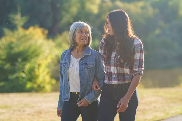 istock Mixed race mother and daughter walk and talk together outside 1345030921
