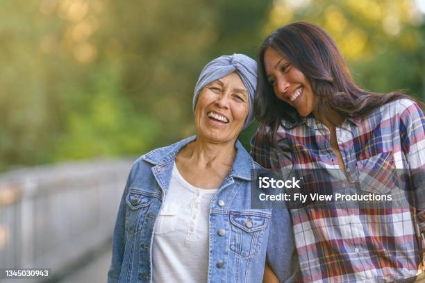 Happy Senior Woman With Cancer Laughing With Daughter Stock Photo - Download Image Now