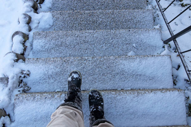 Danger of accident on snow-covered slippery steps of stairs in winter Danger of accident on snow-covered slippery steps of stairs in winter slippery stock pictures, royalty-free photos & images