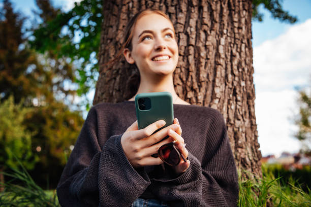 istock Happy smiling young woman on mobile phone 1345033435