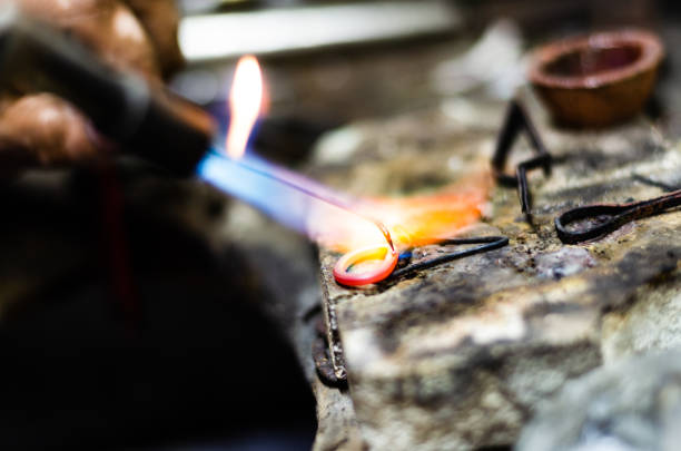 Close up of jeweler making golden ring with flame torch. Close up of jeweler making golden ring with flame torch bangle stock pictures, royalty-free photos & images