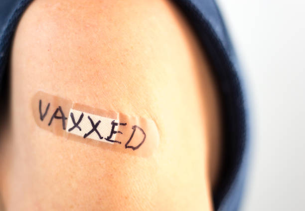 istock Bandage on Woman's Arm Reading VAXXED 1345042818