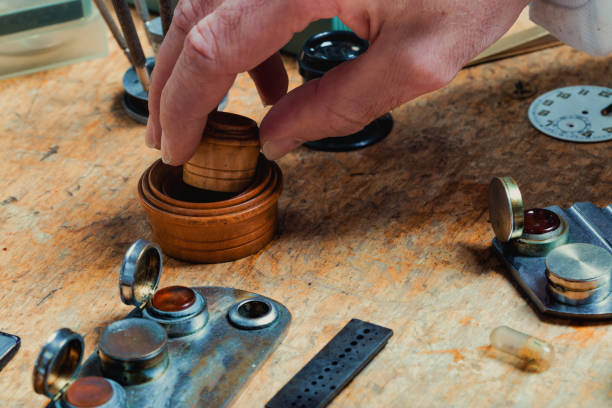 時計職人のワークベンチでツールに手を伸ばす男性の手 - watch maker work tool watch equipment ストックフォトと画像