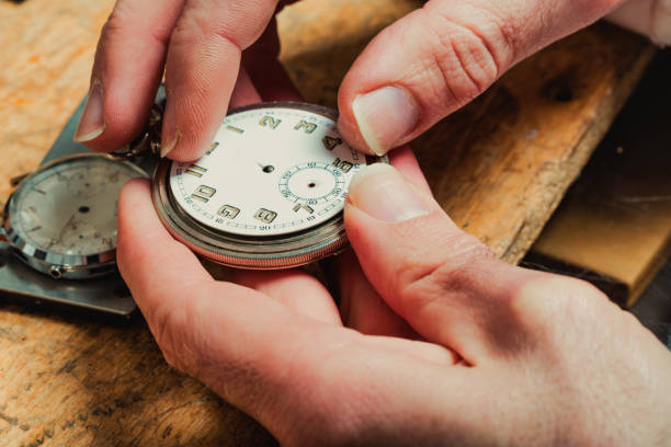 istock Watchmaker replacing the dial on an old watch 1345043963
