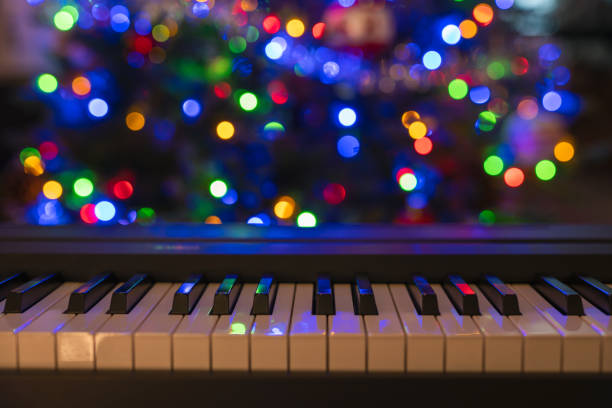 istock Piano keyboard and Christmas pine tree illuminations. Vibrant colors, Holidays concept 1345049687