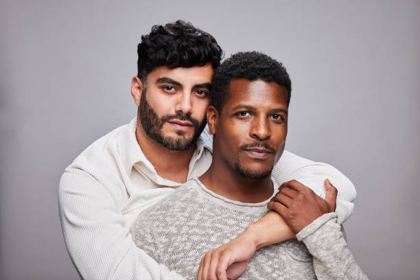 istock Affectionate young gay couple standing against a gray background 1345049925