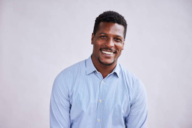 istock Young businessman laughing while standing against a gray background 1345050587