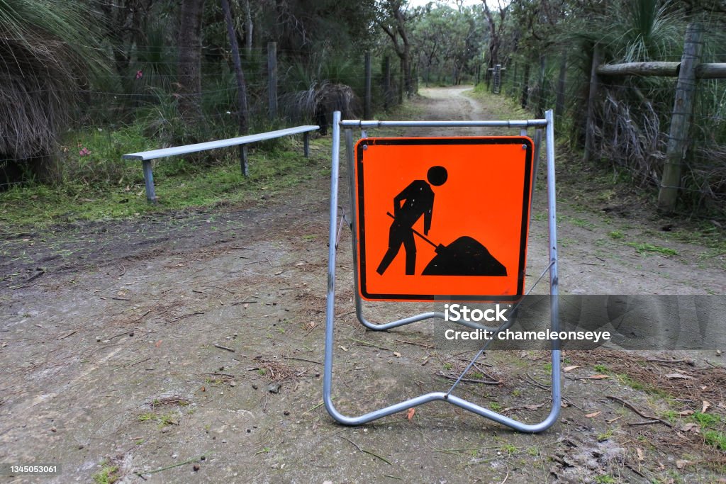 Road work sign on a public park path Road work sign men at work on a public park path. Construction Worker Stock Photo