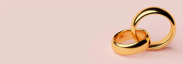 Banner of two wedding gold rings lie on each other with blank space background. 3d rendering