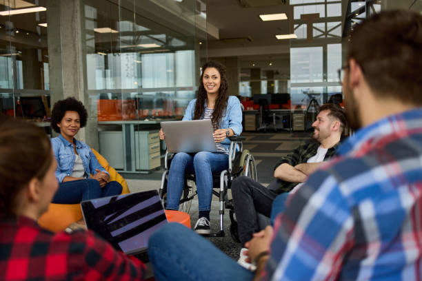 istock Disabled businesswoman discussing with colleagues in office 1345055344