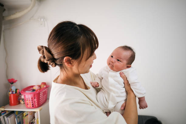 istock Asian mother lifting newborn 1345055991