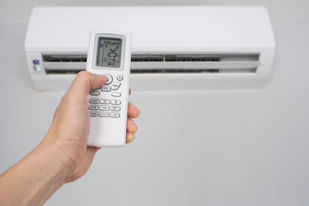 istock Man's hand using remote control open The air conditioner is cooled to 25 degrees Celsius in his bedroom. Health concepts and energy savings 1345057300
