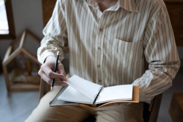istock Cropped shot businessman sitting in comfortable workplace and reading book. 1345060057