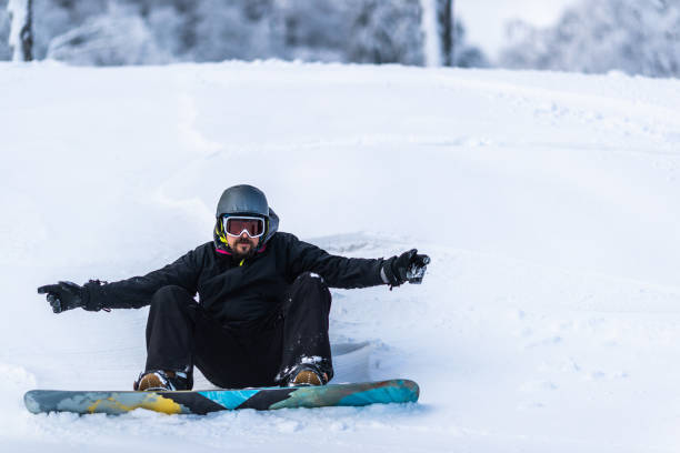 istock Male snowboarder resting in snow on a mountain. 1345060810