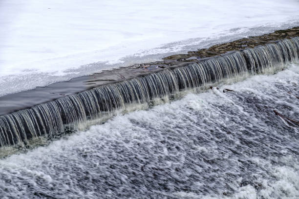 istock A small flat cascade in a calm river with ice in winter. 1345060925