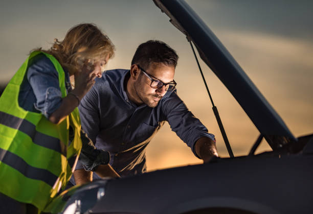 istock Young couple examining their broken car at sunset. 1345061249