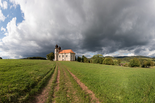 Church of St. Margaret from the 18th century near Šonov. 
Beautiful church chapel in middle of fields in czech countryside broumovsko region with hills of broumov walls on background. Czech landscape.