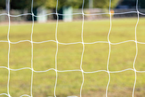 istock Football game arena through soccer nets. Blurred background. 1345062890