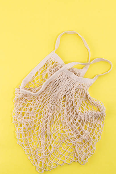 istock Reusable cotton and mesh eco bags for shopping on yellow background with copy space. Zero waste concept. No plastic 1345063361