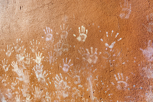 Children's play with chalk, dust color from palms, as handprints on rough wall facade background, childhood design.