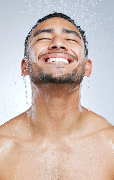 istock Studio shot of a handsome young man taking a shower against a grey background 1345067282