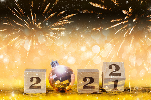 Christmas and New Year golden glittering background with changing number 2022 and Christmas ball with shiny and blurred backdrop