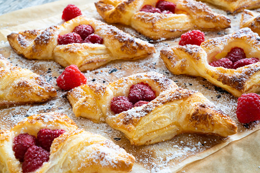 Puff pastry with raspberries on baking paper