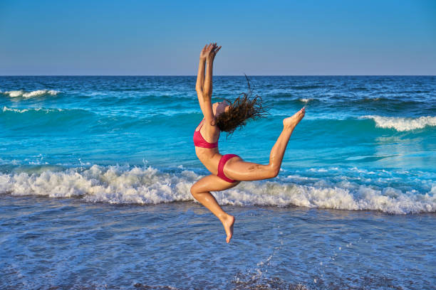 istock acrobatic gymnastics bikini girl in a beach 1345071168
